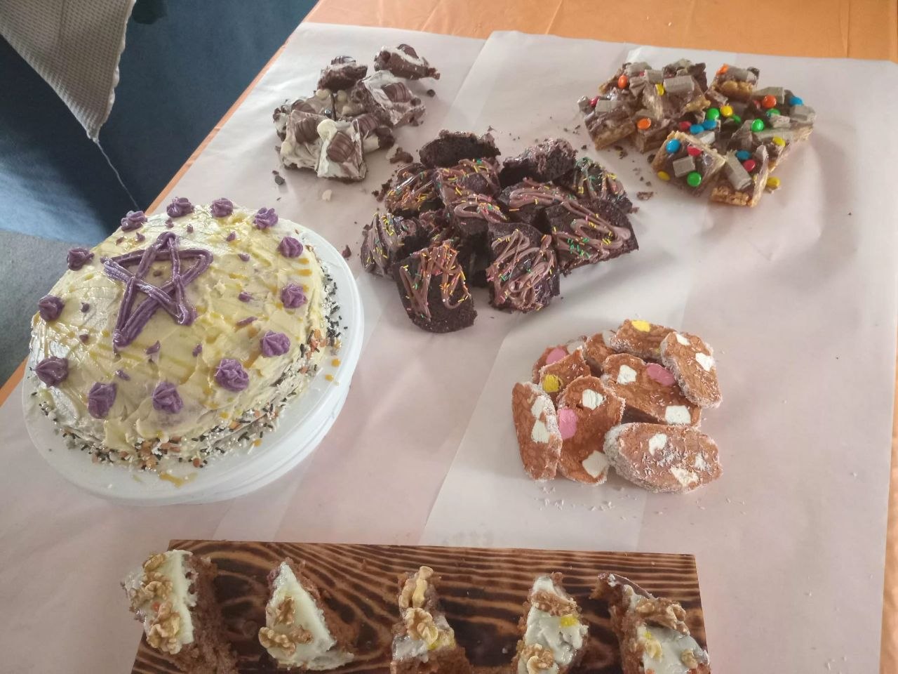 Celebration cake spread with carrot slices and brownies